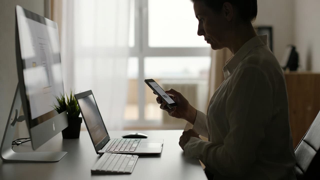 Smartphone mit Arbeitszeiterfassung App auf einem Schreibtisch