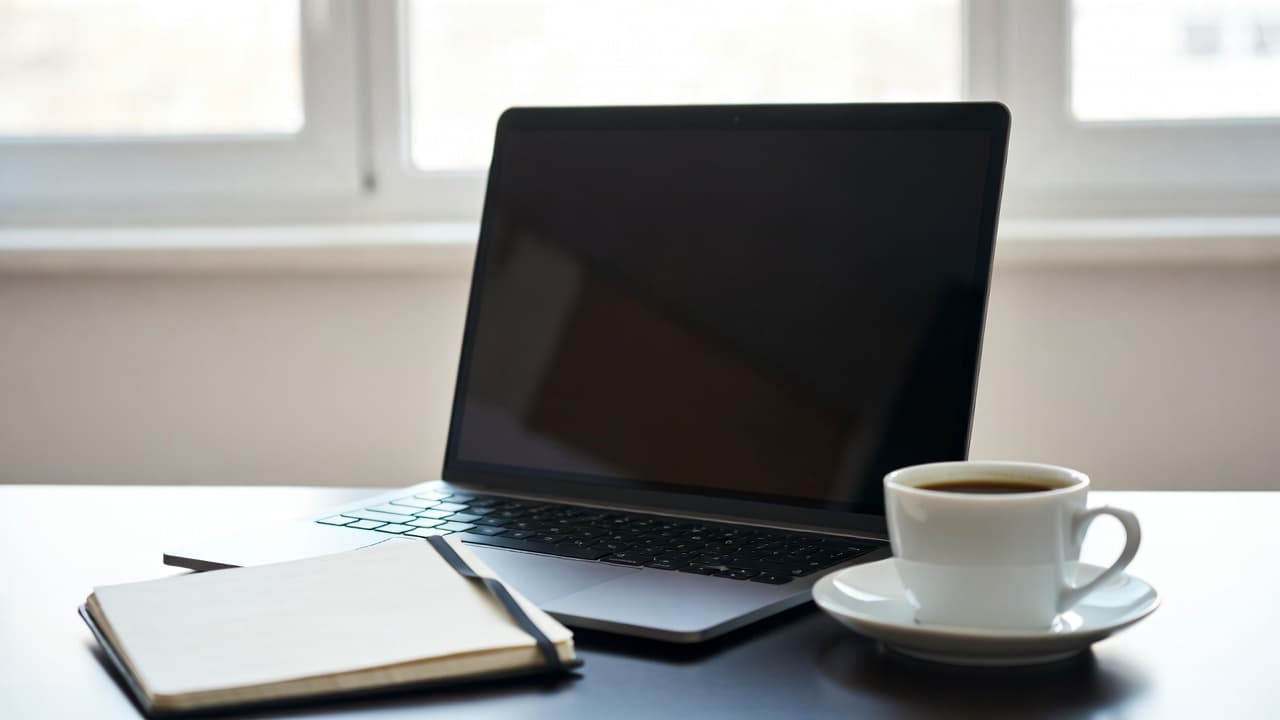 Minimalist workspace with laptop and notebook for simple time tracking
