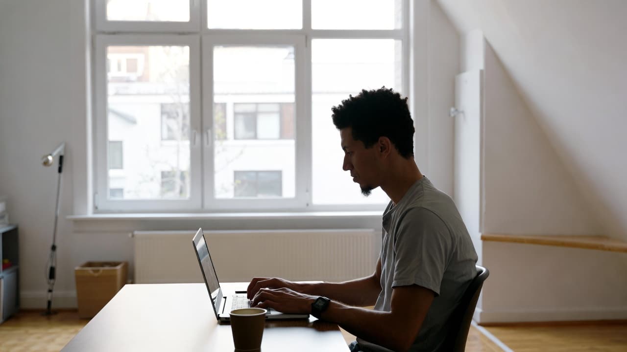 Freelancer working on laptop in bright home office