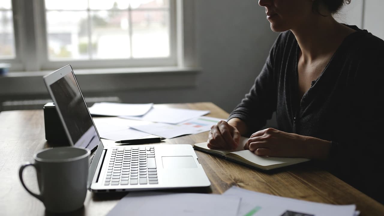 Freelancer arbeitet an Projektzeiten am Küchentisch